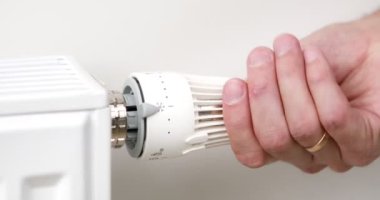 Adam termostatı kurarak ısıtıcıyı kapatır. Yüksek kalite 4k görüntü