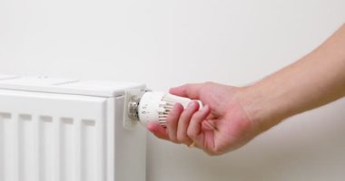 Adam termostatı kurarak ısıtıcıyı kapatır. Yüksek kalite 4k görüntü