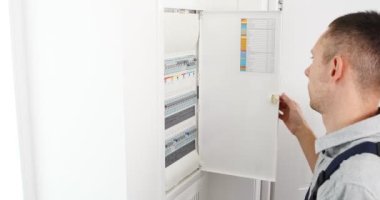 Tamirat yapan bir elektrikçi. Sigorta kutusunda elektrikli aktivatör ekipmanı olan elektrikçinin elleri. 