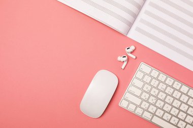 Not defteri ve pembe arka planda bir fincan kahve, düz. müzik defteri