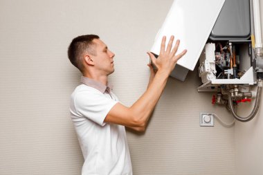 Tesisatçı, Isıtma Cihazları sorununu çözmeye çalışıyor. Gaz kazanının tamiri