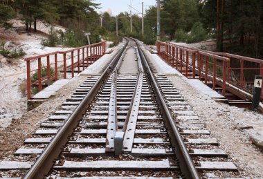 Railway under a thin layer of the first snow. clipart