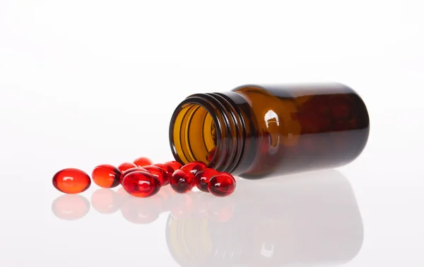 Červené prášky pilulku láhev — Stock fotografie
