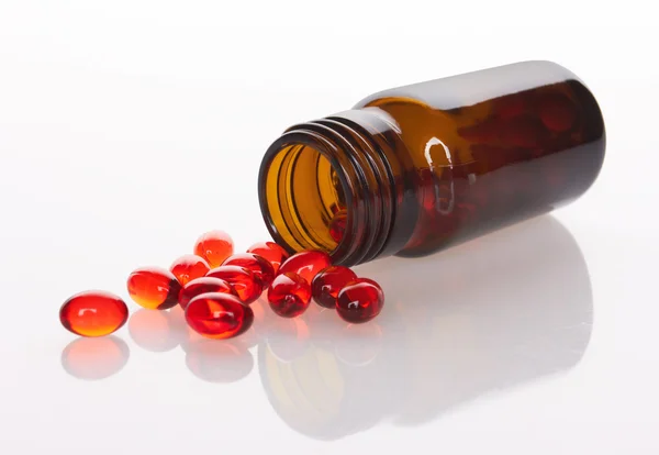 Rote Pillen und Tablettenflasche — Stockfoto