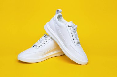 Sarı arka planda beyaz spor ayakkabı