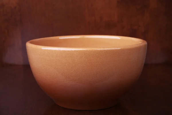 Clay bowl on a wooden background — Stock Photo, Image