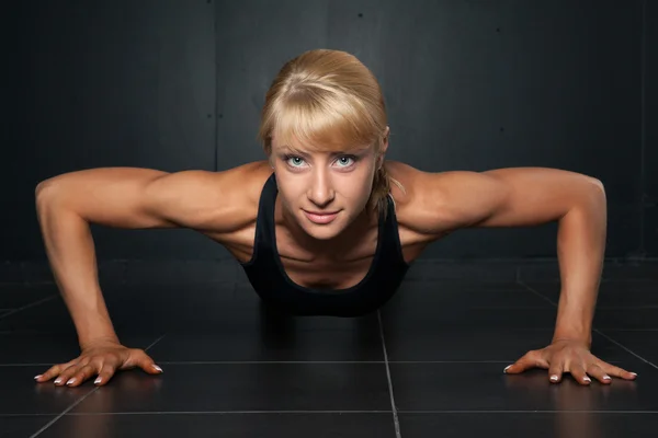 Beautiful athletic woman is pushed up — Stock Photo, Image