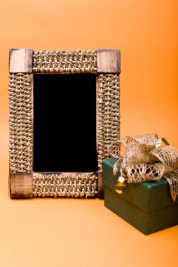 fotoğraf çerçevesi ve hediye kutusu ile turuncu zemin üzerine şerit.