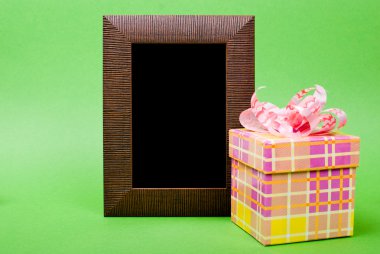 ahşap fotoğraf çerçevesi ve sarı hediye kutusu ile yeşil b pembe kurdele