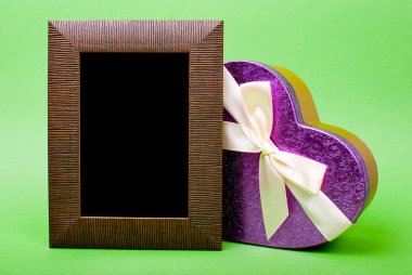 ahşap fotoğraf çerçevesi ve kalp hediye kutusu ile şerit üzerinde yeşil backgro