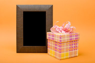 ahşap fotoğraf çerçevesi ve sarı hediye kutusu Turuncu pembe kurdele ile