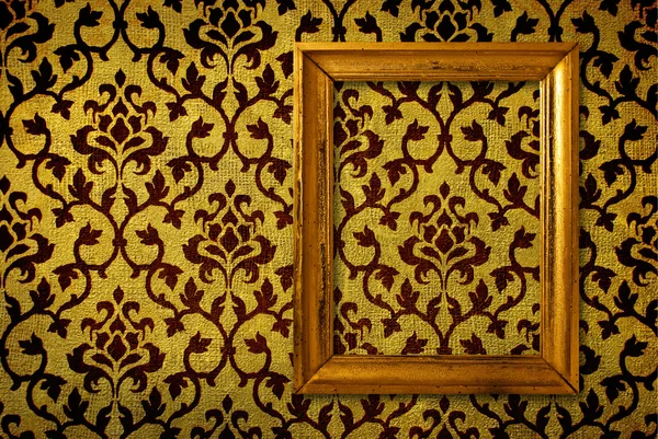 Moldura de ouro em um fundo de parede amarelo vintage — Fotografia de Stock