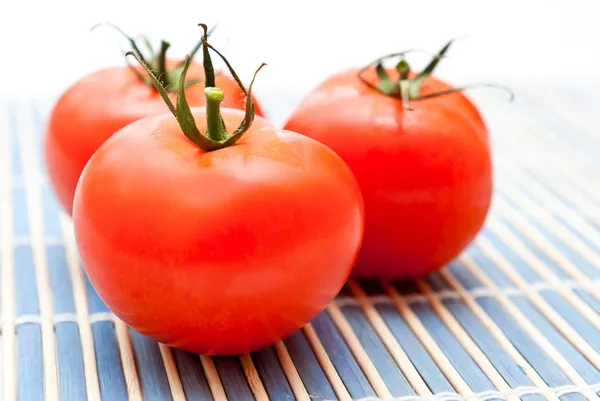 Fresh ripe tomatoes on an chopping board — Stock Photo, Image