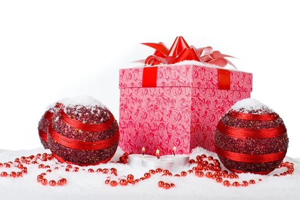 Caja de regalo de Navidad en la nieve con bolas rojas y velas —  Fotos de Stock