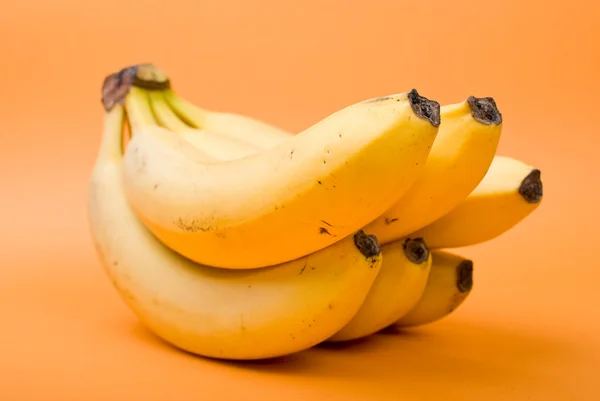 오렌지 배경에서 익은 바나나 다발 — 스톡 사진