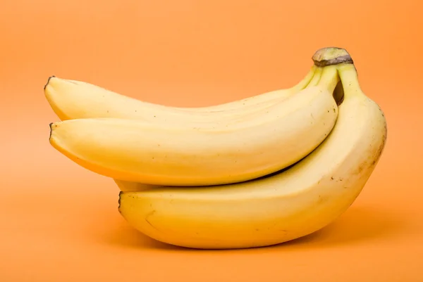 Bouquet de bananes mûres sur fond orange — Photo