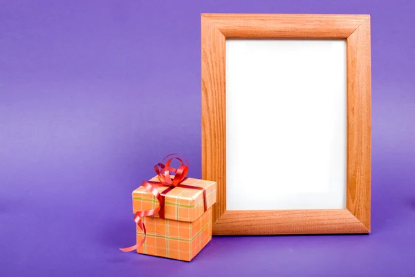 Marco de fotos de madera y caja de regalo naranja con cinta roja en azul b — Foto de Stock