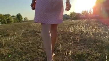 Pembe elbiseli genç sarışın bir kız samanlıkta duruyor..