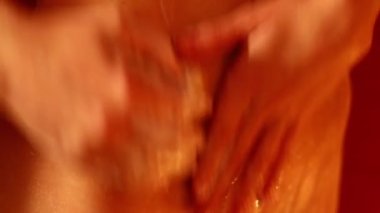 Güzel kız banyoda ince vücut sabunları kullanıyor. Mum ışığı.