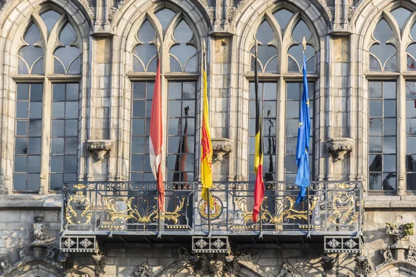 Vlajky na fasádě radnice v mons, Belgie. — Stock fotografie