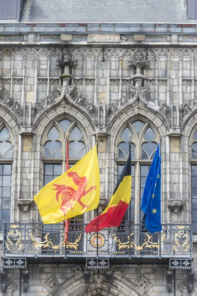 Flagi na elewacji ratusza w mons, Belgia. — Zdjęcie stockowe