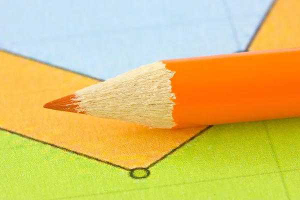 Orange pencil on the colorful paper — Stock Photo, Image