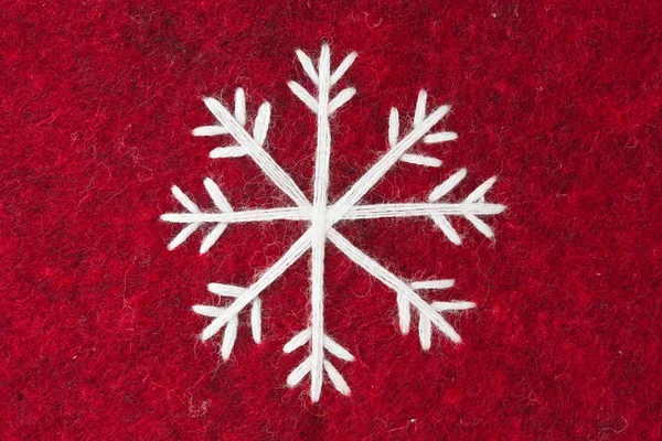 Fieltro rojo con bordado blanco copo de nieve — Foto de Stock