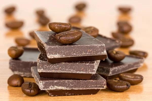 Chicchi di caffè e cioccolati sul tavolo — Foto Stock