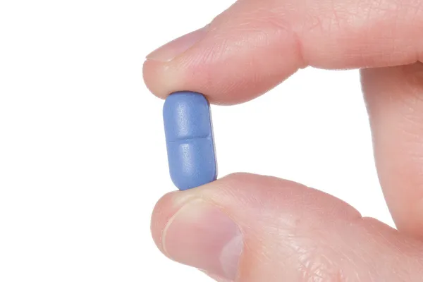 Рукой придерживая синий pil — стоковое фото