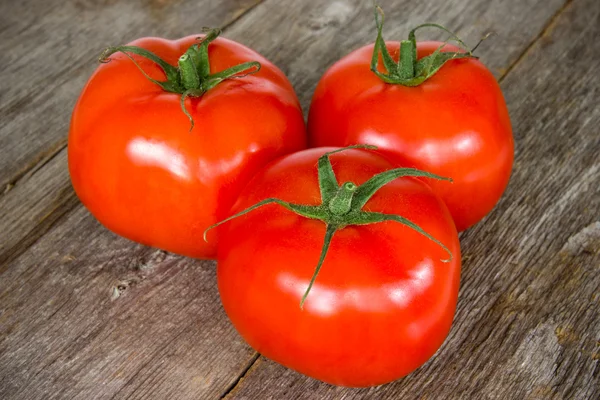 Tomatoes on the old wooden floor — Stock Photo, Image