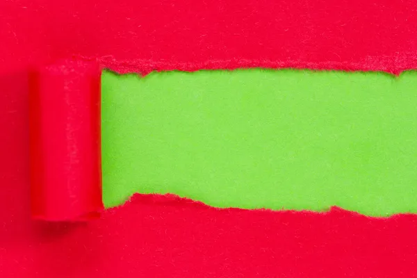 Red paper torn to reveal green panel — Stock Photo, Image