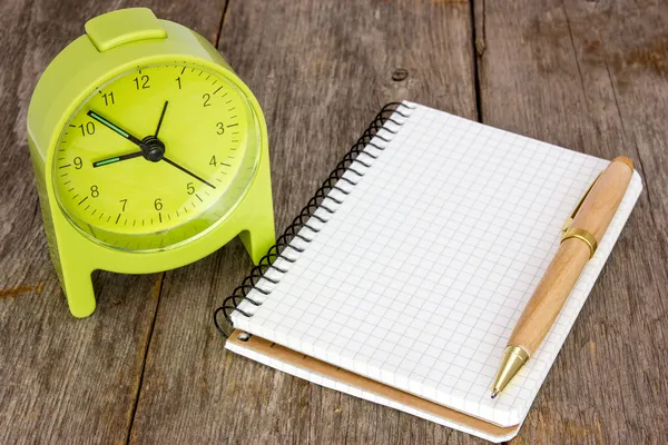 Reloj con alarma y cuaderno en blanco —  Fotos de Stock