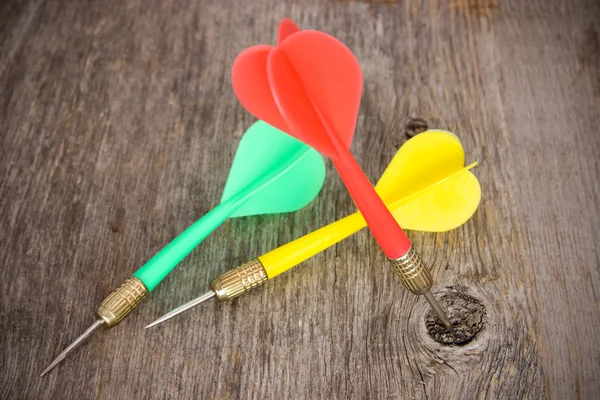 Color darts on a wooden background — Stock Photo, Image