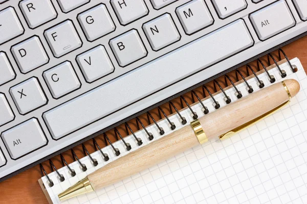 Spiral notebook and computer keyboard — Stock Photo, Image