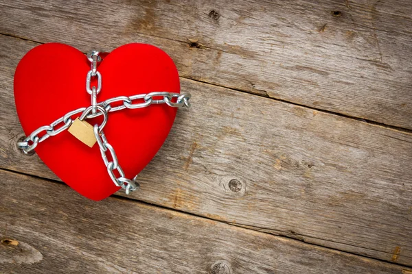 Srdce s řetězy na dřevěné pozadí — Stock fotografie