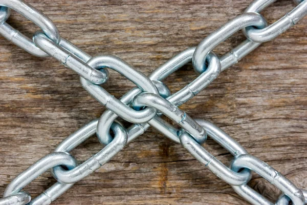 Las cadenas cruzaron sobre el fondo de madera —  Fotos de Stock