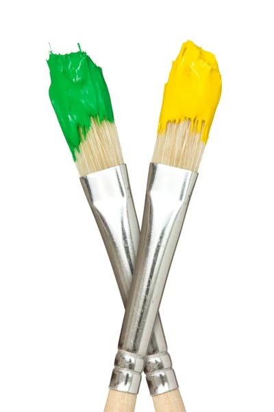 Paint brushes with yellow and green paints — Stock Photo, Image