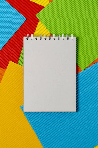 縞模様の色のエンボス加工紙シート上の空白のメモ帳 — ストック写真