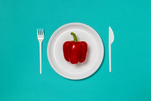 白いプレート上の赤ピーマン フォークとナイフ 健康的な食品の概念 食べ物の創造的な概念 トップ表示ピンク背景フラットコピースペースとレイアウト — ストック写真
