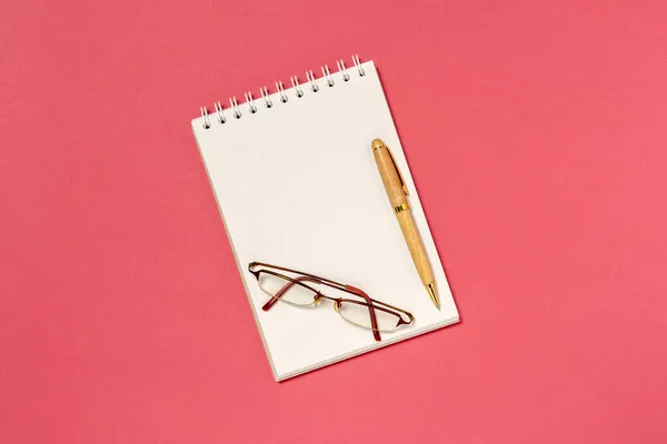 Bovenaanzicht Van Blanco Spiraal Notebook Pen Bril Rode Achtergrond — Stockfoto