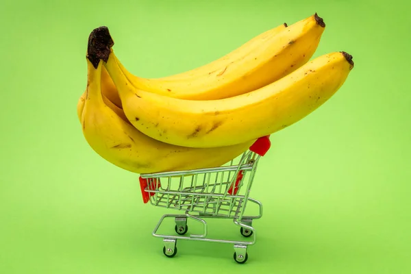 Grocery Shopping Cart Concept Shopping Trolley Full Bananas Green Background — Stock Photo, Image