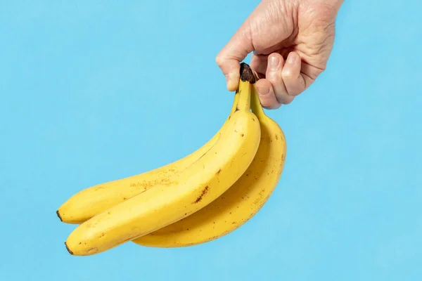 Hand Holding Bunch Yellow Bananas Blue Background — Stock Photo, Image