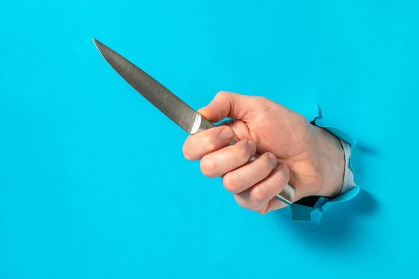 Hand Holding Knife Hole Blue Paper Concept Aggression Space Text — Stock Photo, Image