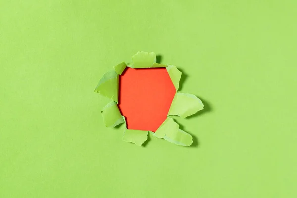 破れた縁と内側の赤い背景を持つ緑の紙の穴 緑の紙をリッピングし スペースをコピー — ストック写真