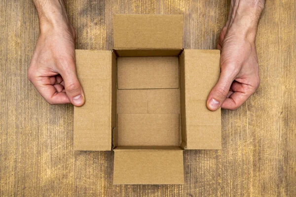 Hands Opening Empty Brown Cardboard Box Top View — Stock Photo, Image