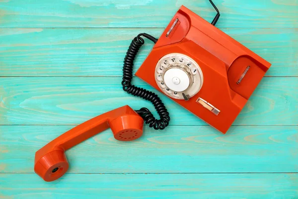 蓝色木制桌子上的旧橙色电话 带有摘下接收机的复古电话 — 图库照片