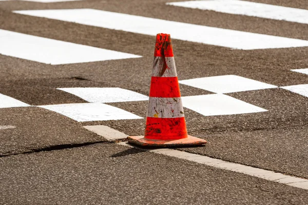 Work on road. Construction cone. Traffic cone, with white and orange stripes on asphalt. Street and traffic signs for signaling. Road maintenance, under construction sign and traffic cone on road.