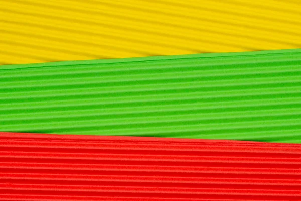 Striped colorful embossed paper. Colored paper background. Yellow,green and red.