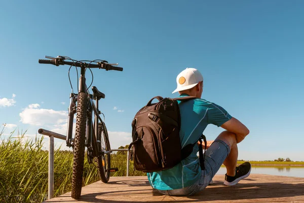 Back View Unrecognizable Man Backpack Sitting Bicycle Wooden Pier Sunny — Stock Photo, Image