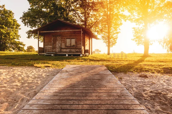 Wooden path from the water to the wooden ecological summerhouse. Sunny, quiet, relaxing place at the lake.